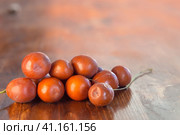 Jujube. Marmalade- jujube or Chinese date on a wooden background. Close-up of a pile of ripe ziziphus, rich in vitamins and minerals, on a wooden surface. Small depth of focus. Ripe sweet berries. Стоковое фото, фотограф Александр Кротков / Фотобанк Лори