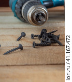 Construction and repair, Home working tool- self-tapping screws on the background of a screwdriver on wooden boards. Self-tapping screws on a wooden background. Стоковое фото, фотограф Александр Кротков / Фотобанк Лори