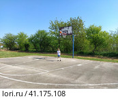 Sremska Mitrovica, Serbia. June 6, 2020. A boy plays ball at the playground. Asphalt sports court. A child in a white t-shirt. Toddler with blond hair, 7 years old. Running, kicking and exercises. Редакционное фото, фотограф Юлия Петровская / Фотобанк Лори