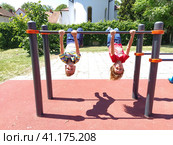 Sremska Mitrovica, Serbia. June 6, 2020. Flip-flops, weight lifting and weights, strength exercises. Two teenagers go in for sports on simulators, children on a sports ground. Редакционное фото, фотограф Юлия Петровская / Фотобанк Лори
