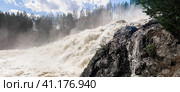 Powerful stream during an idle discharge of water against the background of a building of a small hydroelectric power station. Стоковое фото, фотограф Евгений Харитонов / Фотобанк Лори