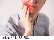 Man suffering from a toothache on gray background. Стоковое фото, фотограф Станислав Тарко / Фотобанк Лори