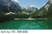 Aerial footage over lake Braies, Pragser Wildsee and mountains, in the background, on a sunny bright summer day, in Dolomites, Italy. Стоковое фото, фотограф Igor Tichonow / Фотобанк Лори