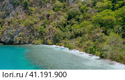 4k drone aerial view of remote paradise beach with palm trees swaying in the wind. Banka boat on azu. Стоковое фото, фотограф Igor Tichonow / Фотобанк Лори
