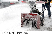 Snowblower removes snow, a man cleans the yard outside. Стоковое фото, фотограф Igor Skripachev / Фотобанк Лори