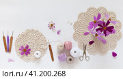 Summer needlework and craft. Process of crochet lace doily. Set of cotton yarn, hooks and bouquet of pink cosmea flowers on white table. DIY concept, handmade gifts. Top view, video, flat lay. Стоковое видео, видеограф Виктория Катьянова / Фотобанк Лори