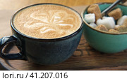 Blue Ceramic Cup of Hot Cappuccino with Flower Shaped Foam on Wooden Cafe Table. Beautiful Latte Art Froth. Trendy Authentic Modern Porcelain Set. Pottery Handmade Coffee Mug Served with a Sugar Bowl. Стоковое видео, видеограф Марина Демидюк / Фотобанк Лори