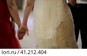 The bride in a white dress and veil holds the hand of a friend in a red dress. Невеста в белом платье и фате держит за руку подругу в красном платье. Стоковое видео, видеограф Egor Sarantstv / Фотобанк Лори
