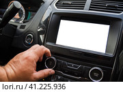 The male driver controls the settings of the car car audio system. Водитель-мужчина управляет настройками автомобильной аудиосистемы. Стоковое фото, фотограф Дмитрий Березнев / Фотобанк Лори