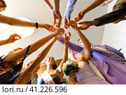 Руки молодых людей, снятые с нижнего ракурса, с бокалами вина, соединенные между собой, образуют подобие цветка с лепестками (2022 год). Редакционное фото, фотограф Сергей Никифоров-Гордеев / Фотобанк Лори