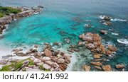 Aerial drone 4k forward flight towards hidden idyllic tropical beach Anse Marron at La Digue island. Стоковое фото, фотограф Igor Tichonow / Фотобанк Лори