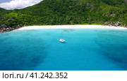 Aerial view footage of luxury catamaran yacht moored in clear turquoise blue ocean water of Petite A. Стоковое видео, видеограф Igor Tichonow / Фотобанк Лори