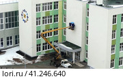 Russia, Nizhny Novgorod, Gagarin Avenue 101, School No. 34, 01.04.2021. The brigade mounts signage or advertising on the facade of the building with the use of special equipment to work at altitude. Россия, Нижний Новгород, проспект Гагарина, 101, школа № 34, 01.04.2021. Бригада монтирует вывески или рекламу на фасаде здания с использованием специального оборудования для работы на высоте. Редакционное видео, видеограф Egor Sarantstv / Фотобанк Лори