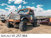 SUVs with specially reinforced suspension stand in the field before the start of the rally (2023 год). Редакционное фото, фотограф Сергей Сергеев / Фотобанк Лори