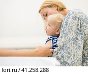 Child beeing vaccinated by pediatrician in presence of his mother. Preventive vaccination against Diphtheria, whooping cough, tetanus, hepatitis, haemophilus influenzae, pneumococcus, poliomyelitis. Стоковое фото, фотограф Matej Kastelic / Фотобанк Лори