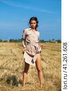 Young beautiful brunette model in a beige dress posing against the background of a mowed wheat field. Стоковое фото, фотограф Андрей Аркуша / Фотобанк Лори