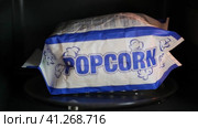 A man takes out a bag of ready-made popcorn from the microwave (2021 год). Редакционное видео, видеограф Алексей Гекало / Фотобанк Лори