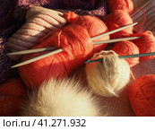 Tangles, snarls. Balls of yarn and thread, knitted clothes, knitting needles and crochet hooks. Pink, purple, red and white threads in skeins. Defocused image. Knitting and weaving as a hobby. Стоковое фото, фотограф Юлия Петровская / Фотобанк Лори