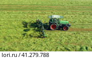 A tractor turns up the grass, aerial view. Стоковое видео, видеограф Артем Лукин / Фотобанк Лори