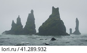 The black sand beach of Reynisfjara with waves hitting the shore on foggy rainy stormy day Vik, Icel. Стоковое видео, видеограф Igor Tichonow / Фотобанк Лори