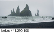 The black sand beach of Reynisfjara with waves hitting the shore on foggy rainy stormy day Vik, Icel. Стоковое видео, видеограф Igor Tichonow / Фотобанк Лори