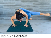side crow pose variation parsva bacasana yoga with ukrainian woman making it indoors. Стоковое фото, фотограф Татьяна Терехина / Фотобанк Лори
