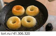 Frying process homemade and delicious donuts on fresh oil in a pan. Blue sugar topping on donuts in a home candy workshop. Pastry, sweet. Making dessert being deep fried. Preparation of donuts. Стоковое видео, видеограф Марина Демидюк / Фотобанк Лори