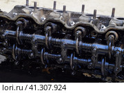 The head of the block of cylinders. The head of the block of cylinders removed from the engine for repair. Parts in engine oil. Car engine repair in the service. Стоковое фото, фотограф Леонид Еремейчук / Фотобанк Лори