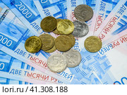 Russian banknotes and coins. A handful of coins on new Russian banknotes in denominations of 2000 and 200 rubles. Стоковое фото, фотограф Леонид Еремейчук / Фотобанк Лори