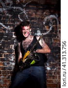 Horrific madman on a dark background and chainesaw. Стоковое фото, фотограф Андрей Аркуша / Фотобанк Лори