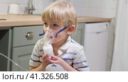 Sick Baby Boy with making Inhalation with a Mask on his Face sitting in Living Room at Home. Children Healing. Child Inhalation therapy with Compressor nebulizer. Inhaling fumes medication into lungs. Стоковое видео, видеограф Марина Демидюк / Фотобанк Лори