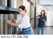 woman is considering MDF boards for internal insulation of residential premises. Стоковое фото, фотограф Яков Филимонов / Фотобанк Лори