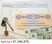 Государственный сертификат материнский (семейный) капитал, договор купли-продажи недвижимости, план квартиры, российский паспорт, деньги и ключи от дверного замка (2023 год). Редакционное фото, фотограф Цибаев Алексей / Фотобанк Лори