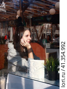 Nice girl in a cafe put her chin on her hand and thought. Стоковое фото, фотограф Константин Григорьев / Фотобанк Лори
