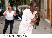Street thief running away after stealing handbag from woman. Стоковое фото, фотограф Яков Филимонов / Фотобанк Лори