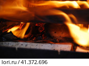 Огонь полыхает между дровами, сложенными друг на друга. Несколько сосновых и березовых поленьев сложены в квадратную башню, в центре которой ярко горят дрова и щепа. Стоковое фото, фотограф Andrew_Swarga / Фотобанк Лори