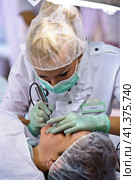 Cosmetologists perform a procedure to rejuvenate facial skin cosmetics Aravia at the festival of beauty Nevskie Berega in St. Petersburg 2012. Редакционное фото, фотограф Анна Кривицкая / Фотобанк Лори