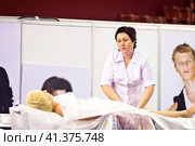 Cosmetologists perform a procedure to rejuvenate facial skin cosmetics Aravia at the festival of beauty Nevskie Berega in St. Petersburg 2012. Редакционное фото, фотограф Анна Кривицкая / Фотобанк Лори