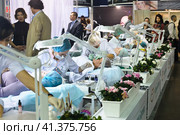 Cosmetologists perform a procedure to rejuvenate facial skin cosmetics Aravia at the festival of beauty Nevskie Berega in St. Petersburg 2012. Редакционное фото, фотограф Анна Кривицкая / Фотобанк Лори