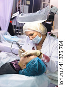 Cosmetologists perform a procedure to rejuvenate facial skin cosmetics Aravia at the festival of beauty Nevskie Berega in St. Petersburg 2012. Редакционное фото, фотограф Анна Кривицкая / Фотобанк Лори
