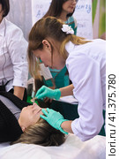 Cosmetologists perform a procedure to rejuvenate facial skin cosmetics Aravia at the festival of beauty Nevskie Berega in St. Petersburg 2012. Редакционное фото, фотограф Анна Кривицкая / Фотобанк Лори