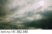 Dramatic and moody time lapse shot on the seacoast. Sunrays breaking through motion clouds. Scenery. Стоковое видео, видеограф Igor Tichonow / Фотобанк Лори