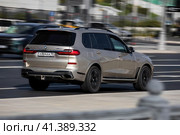 Ivory BMW X7 car moving on the street on high speed. Fast moving SUV on the highway road, rear side view. Редакционное фото, фотограф Константин Григорьев / Фотобанк Лори