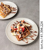 Belgian waffles with chocolate, berries and nuts. Close-up on a gray background. Стоковое фото, фотограф Bogdanova Mariia / Фотобанк Лори