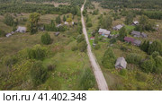 Lonely country road between low wooden houses. Стоковое видео, видеограф Гурьянов Андрей / Фотобанк Лори