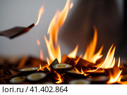 burning paper Money in fire falls on business table. The concept of bankruptcy, depreciation, devaluation, wastefulness and waste of money, AI. Стоковое AI-изображение, AI-художник Sergey Grishin / Фотобанк Лори