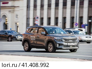 Fast moving Kia Seltos crossover rides on a city road. Gray SUV car on street in motion. Редакционное фото, фотограф Константин Григорьев / Фотобанк Лори