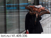 Женщина с зонтом идет по улице во время проливного дождя с порывистым ветром по Ленинградскому шоссе в городе Москве, Россия (2023 год). Редакционное фото, фотограф Николай Винокуров / Фотобанк Лори