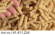 Gluten Free Cornmeal Pasta Wallpaper. Spiral Raw Macaroni from Corn and Rice flour rotating on Turntable. Close Up Top View. Uncooked Pasta Spinning. Full Frame. Food Background. Fusilli Bucati Corti. Стоковое видео, видеограф Марина Демидюк / Фотобанк Лори