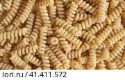 Gluten Free Cornmeal Pasta Wallpaper. Spiral Raw Macaroni from Corn and Rice flour rotating on Turntable. Close Up Top View. Uncooked Pasta Spinning. Full Frame. Food Background. Fusilli Bucati Corti. Стоковое видео, видеограф Марина Демидюк / Фотобанк Лори